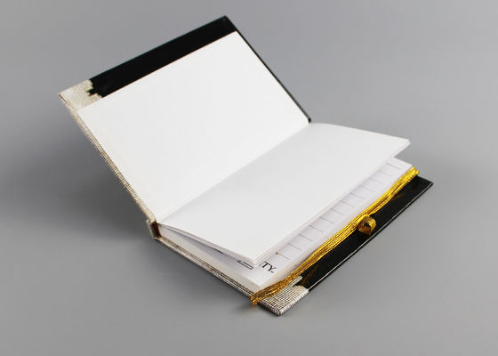 O elástico prende com correias o caderno da capa dura A4, o preto e o jornal do caderno do livro encadernado do ouro